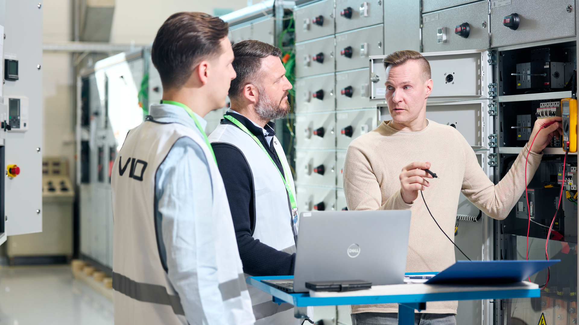 VEO Academy hands on training asiakkaille. VEOn asiantuntija ja asiakkaan edustajat sähkökaapin luona. VEOn asiantuntija kouluttaa asiakkaan työntekijöitä.